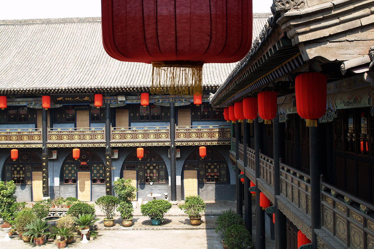 Pingyao courtyard house with red lanterns and traditional balconies