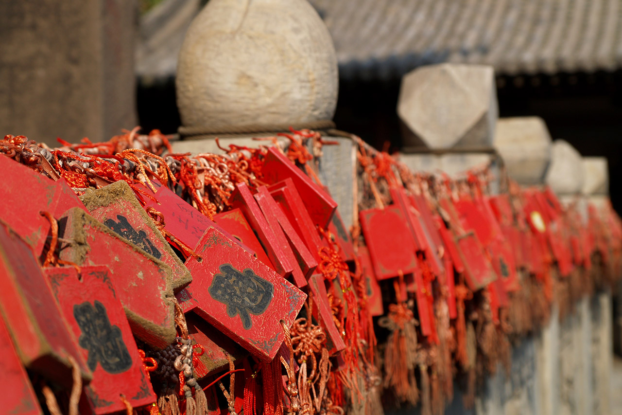 Row of red wooden prayer plaques with Chinese characters