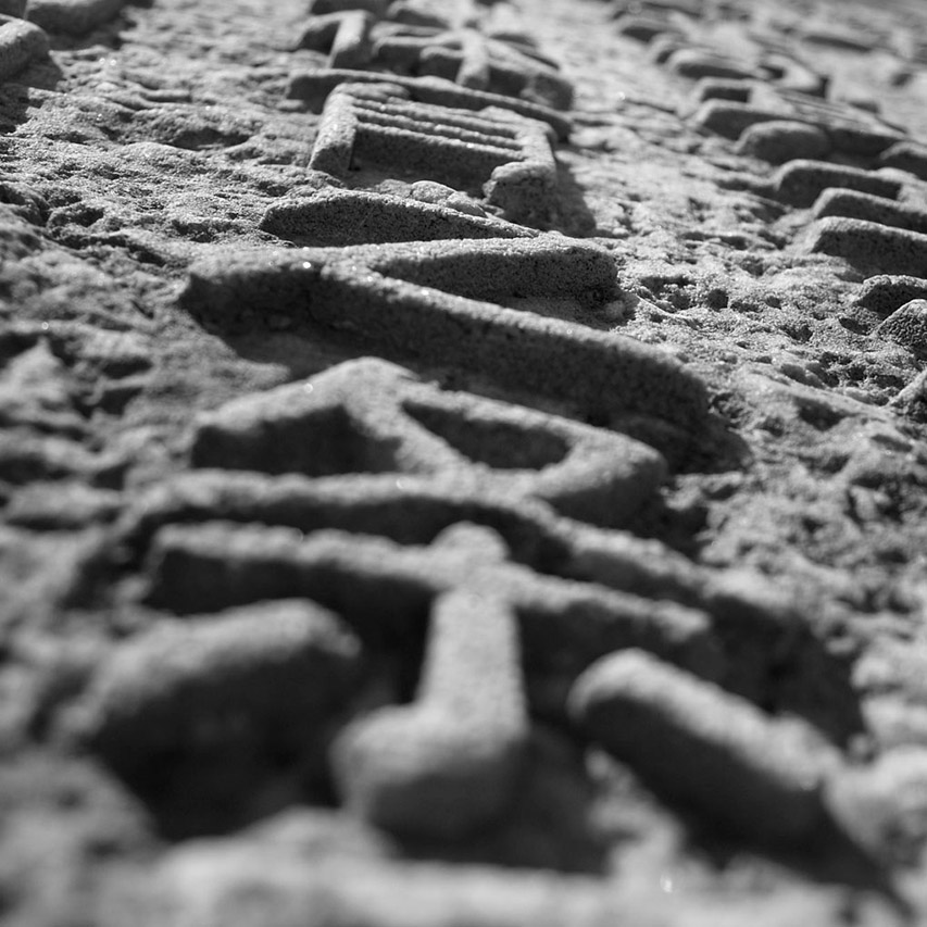 Close-up of Chinese characters carved in sand