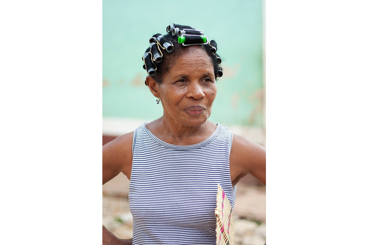 Cuban woman with hair rollers wearing a striped top