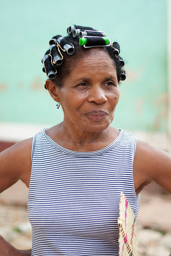 Cuban woman with hair rollers wearing a striped top