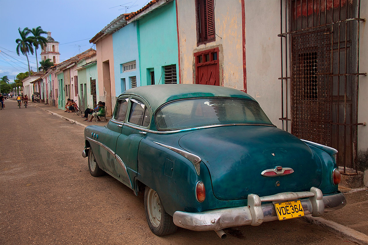 Vintage teal sedan on a colorful colonial street in Remedios, Cuba