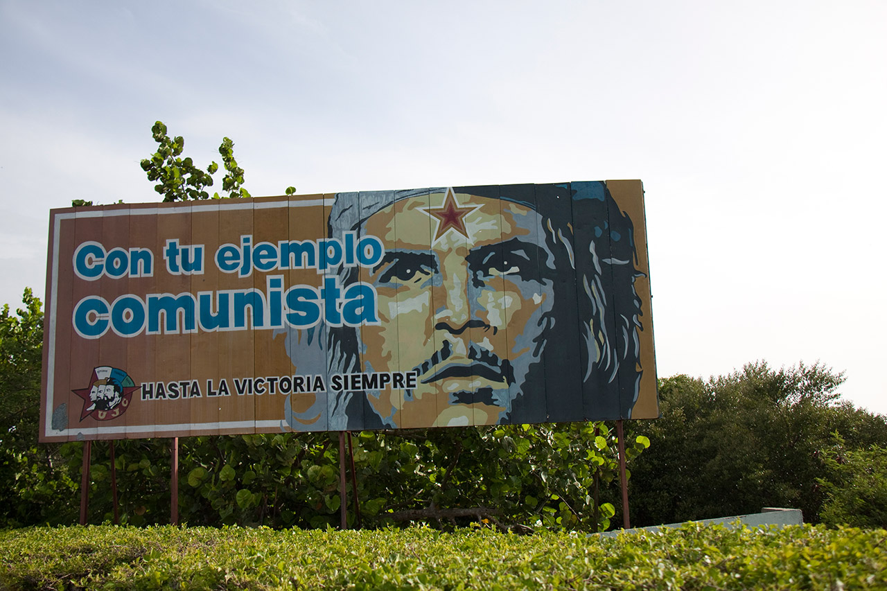 Roadside billboard with Che Guevara portrait: Con tu ejemplo comunista, Cuba