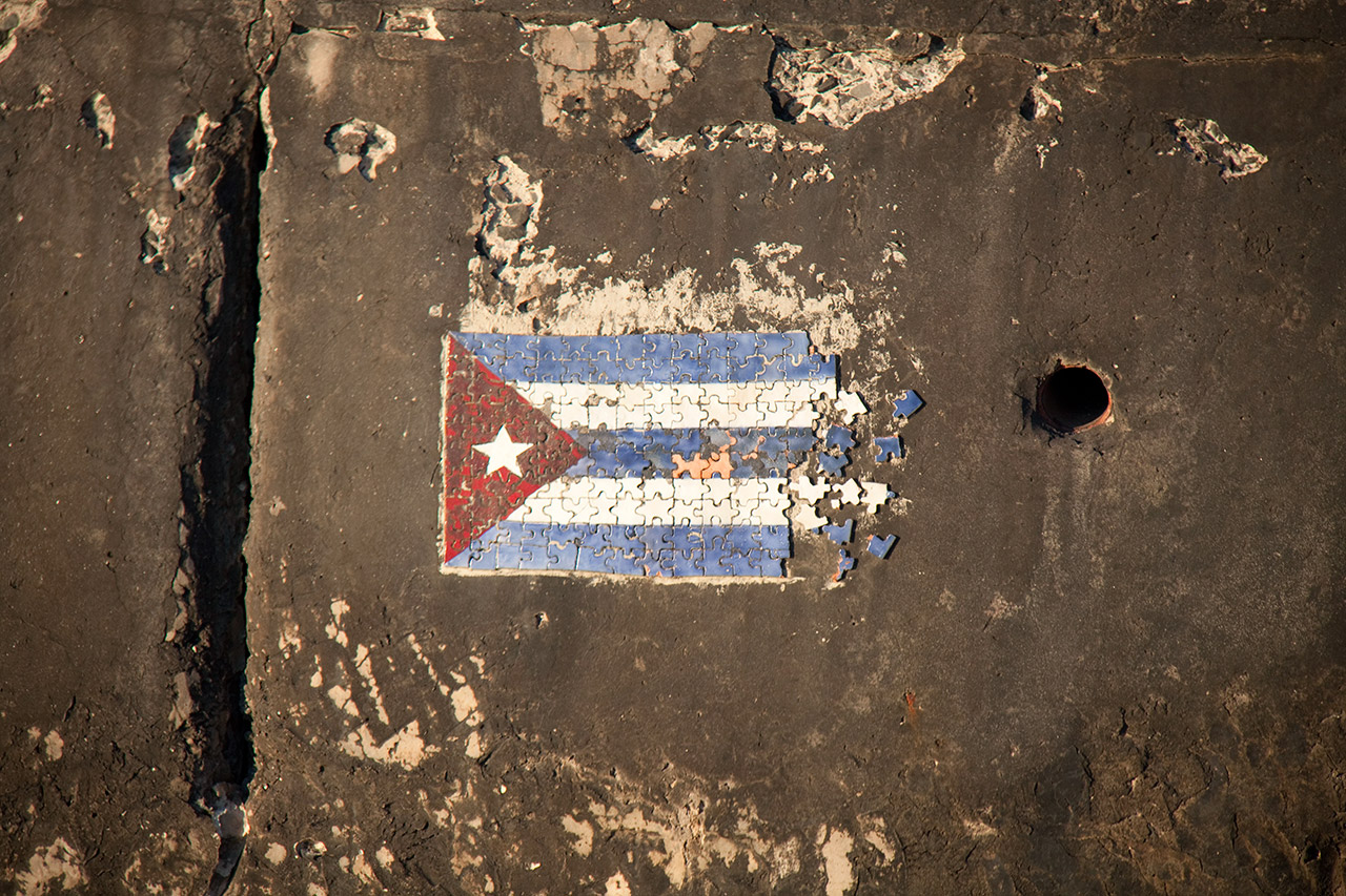 Cuban flag puzzle painted on cracked pavement, Havana