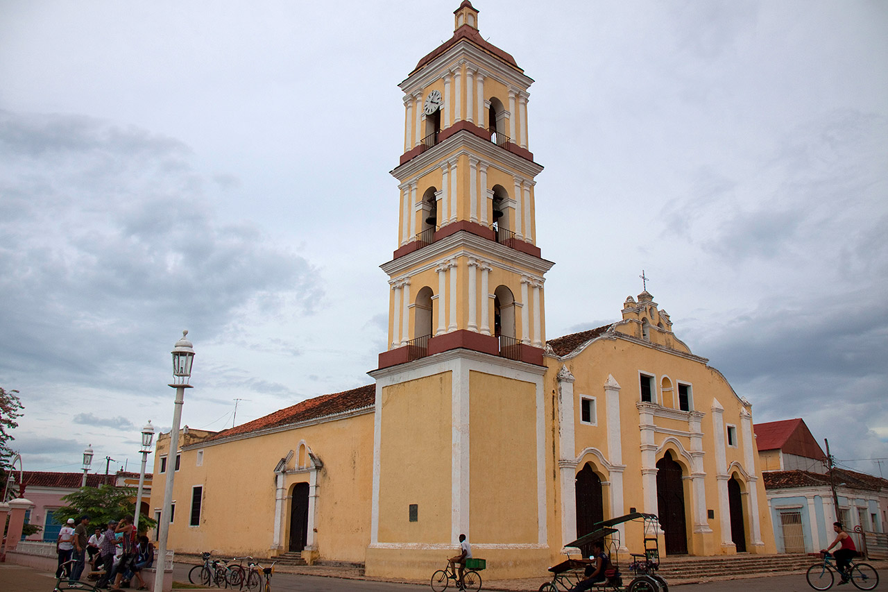 Yellow colonial church with bell tower and bicycle taxis, Remedios, Cuba