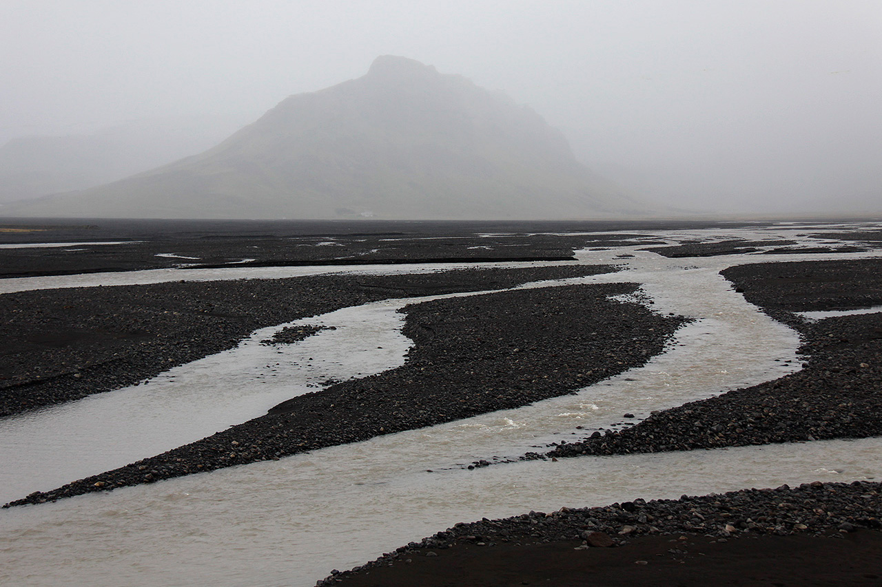 Glacial river braids on black volcanic plain