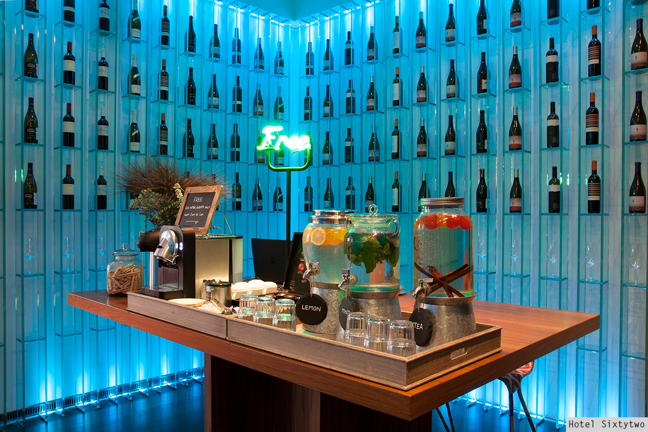 Backlit wine wall with neon Free sign and infused water dispensers at Hotel Sixtytwo