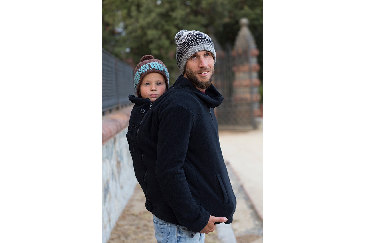 Father carrying child on back, both wearing knit hats — Momawo