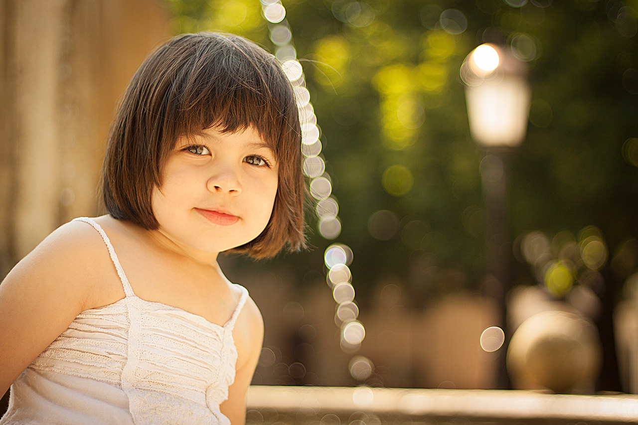 Portrait of a girl by a fountain with bokeh lights