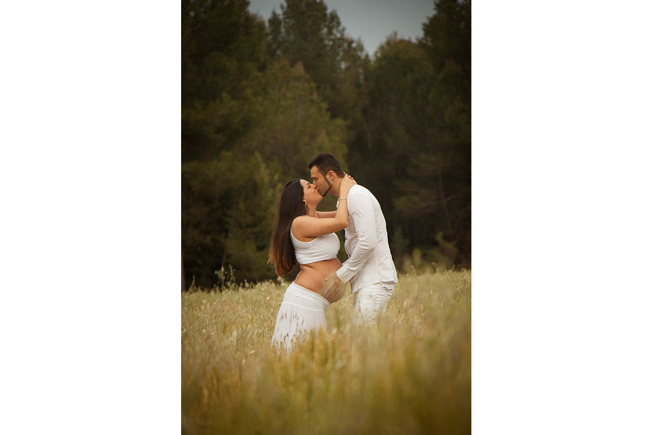 Couple in white kissing in a wheat field