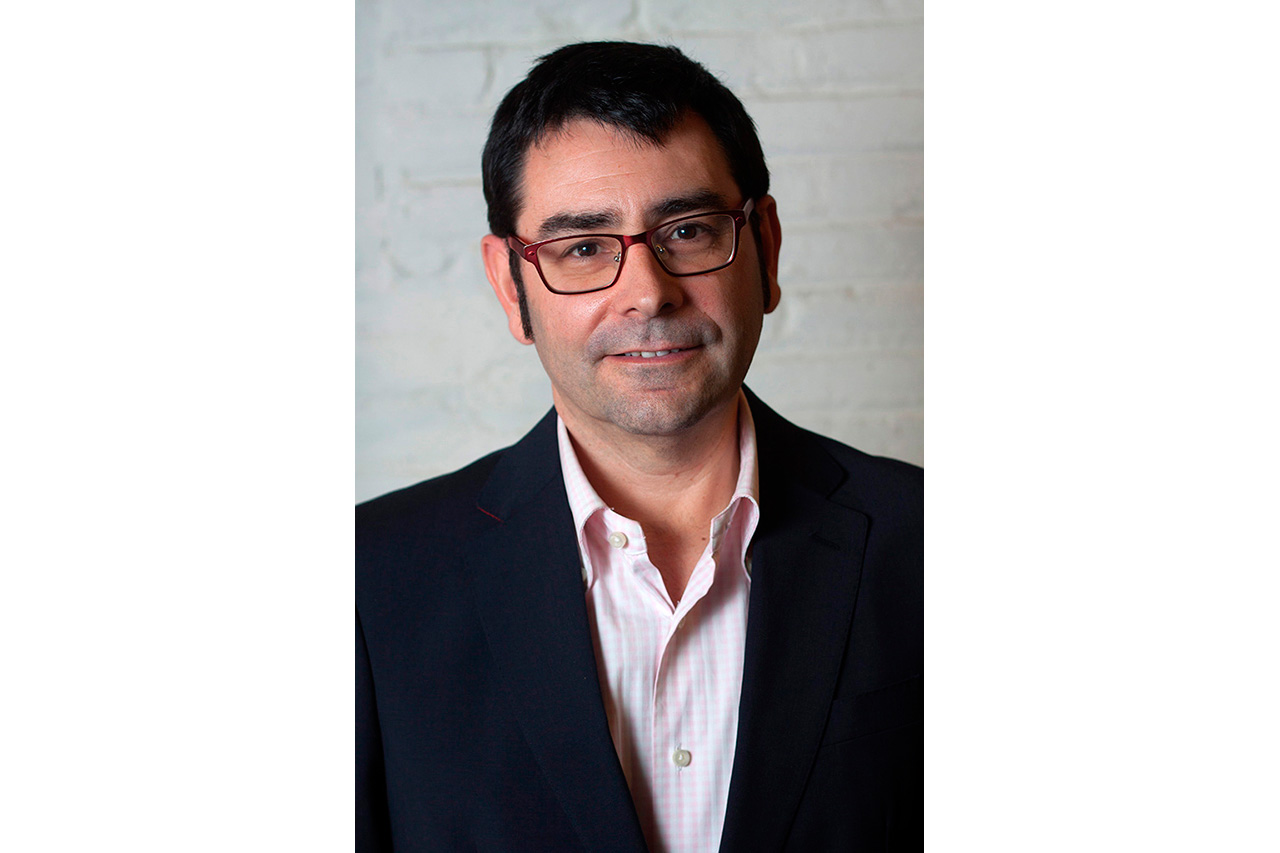 Studio portrait of man with glasses against brick wall