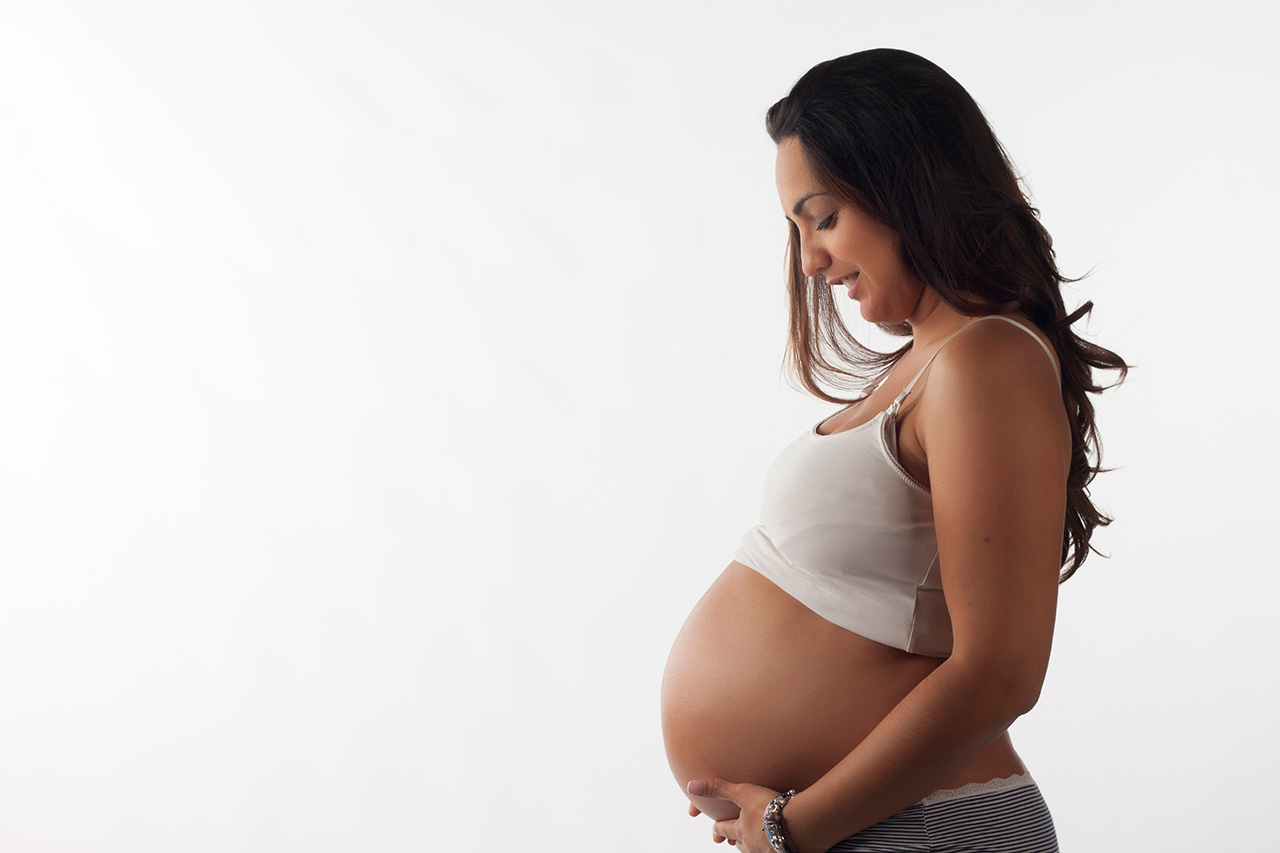 Studio portrait of pregnant woman on white background