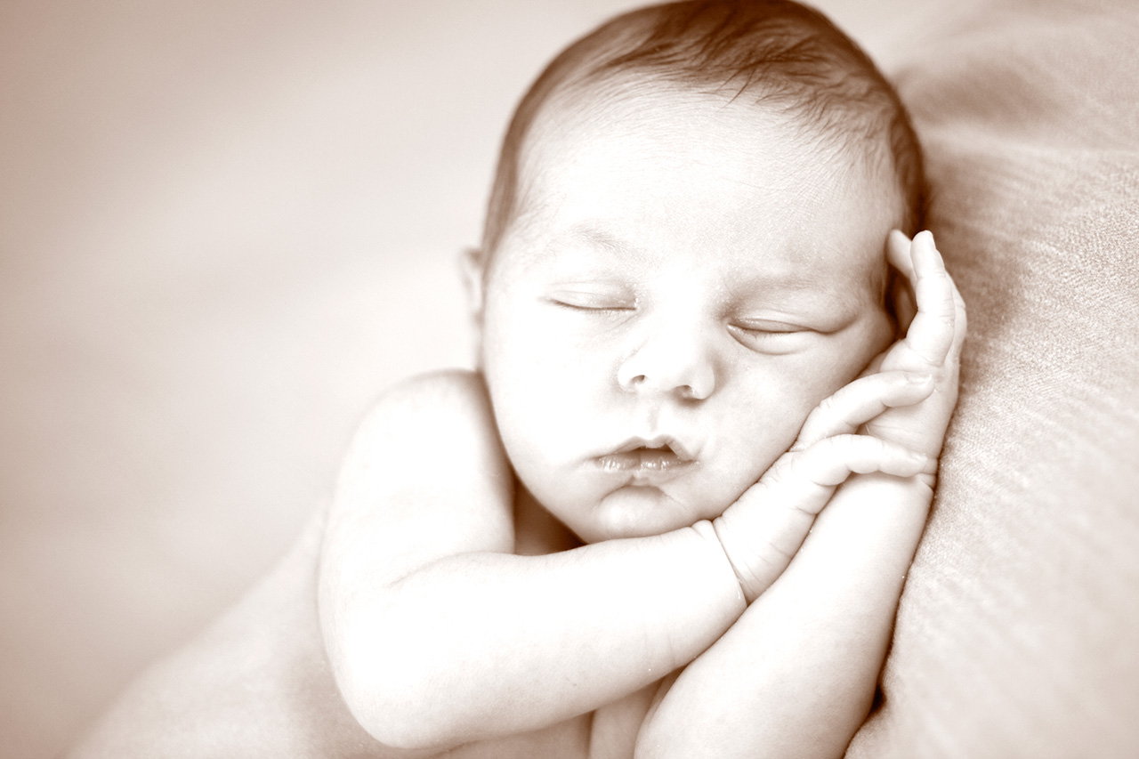 Sepia studio portrait of sleeping newborn
