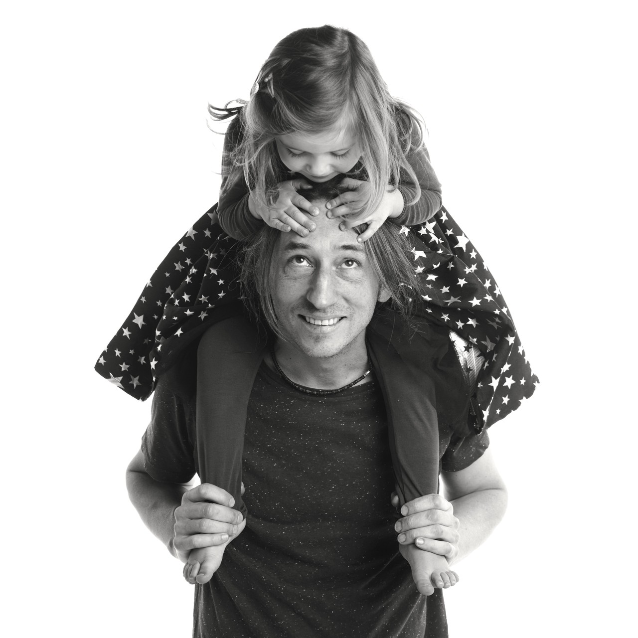 Black and white studio portrait of father with daughter on his shoulders