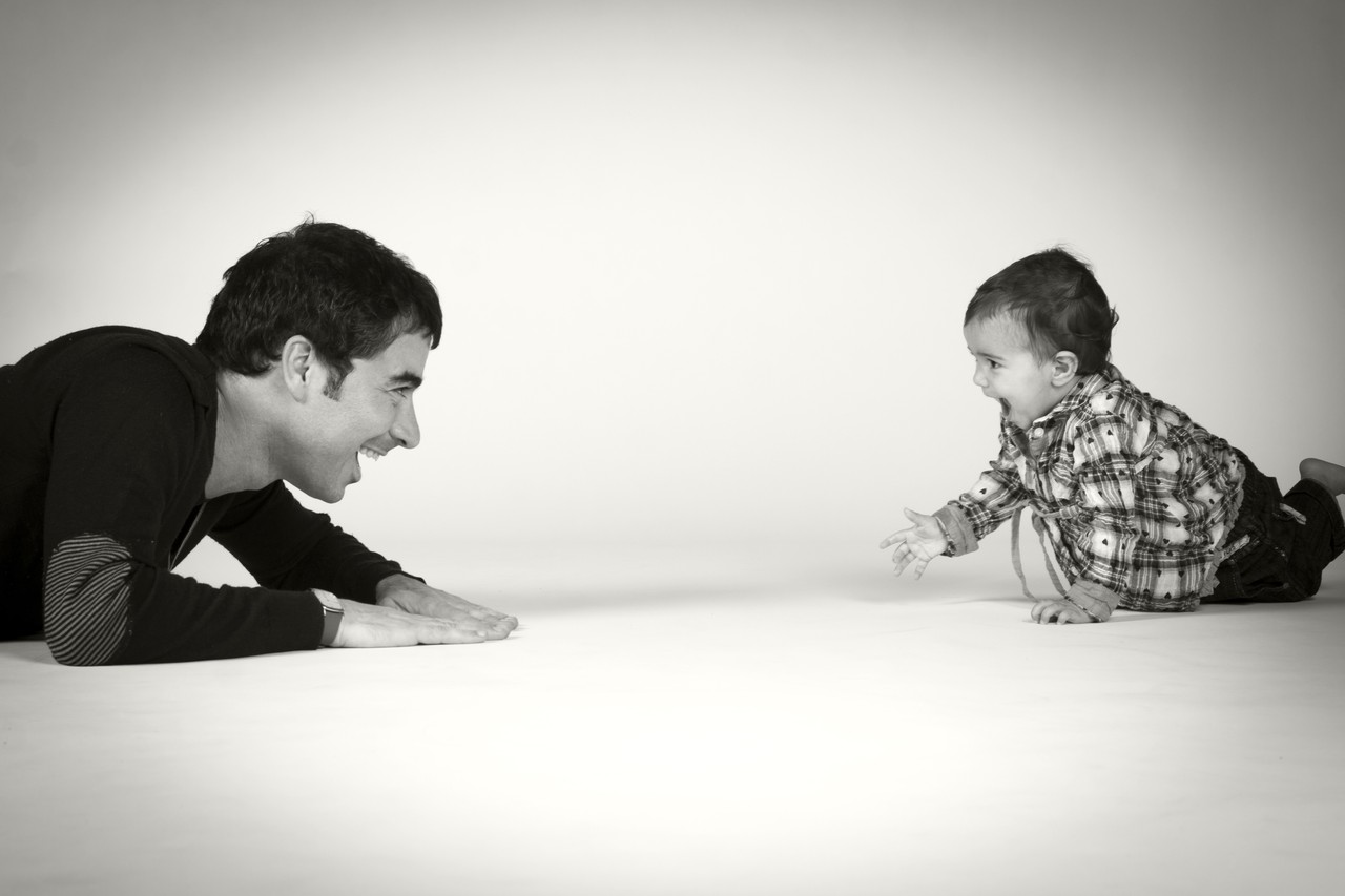 Black and white studio portrait of pregnant woman with daughter holding letters