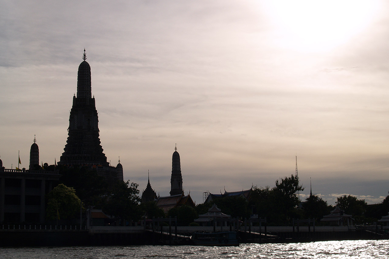 Silhouette of Wat Arun spires at sunset over the Chao Phraya river, Bangkok