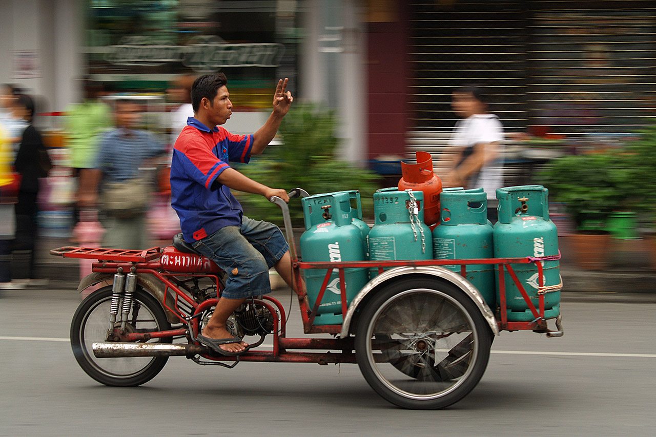 Delivery rider carrying gas cylinders on a red motorbike cart, Bangkok