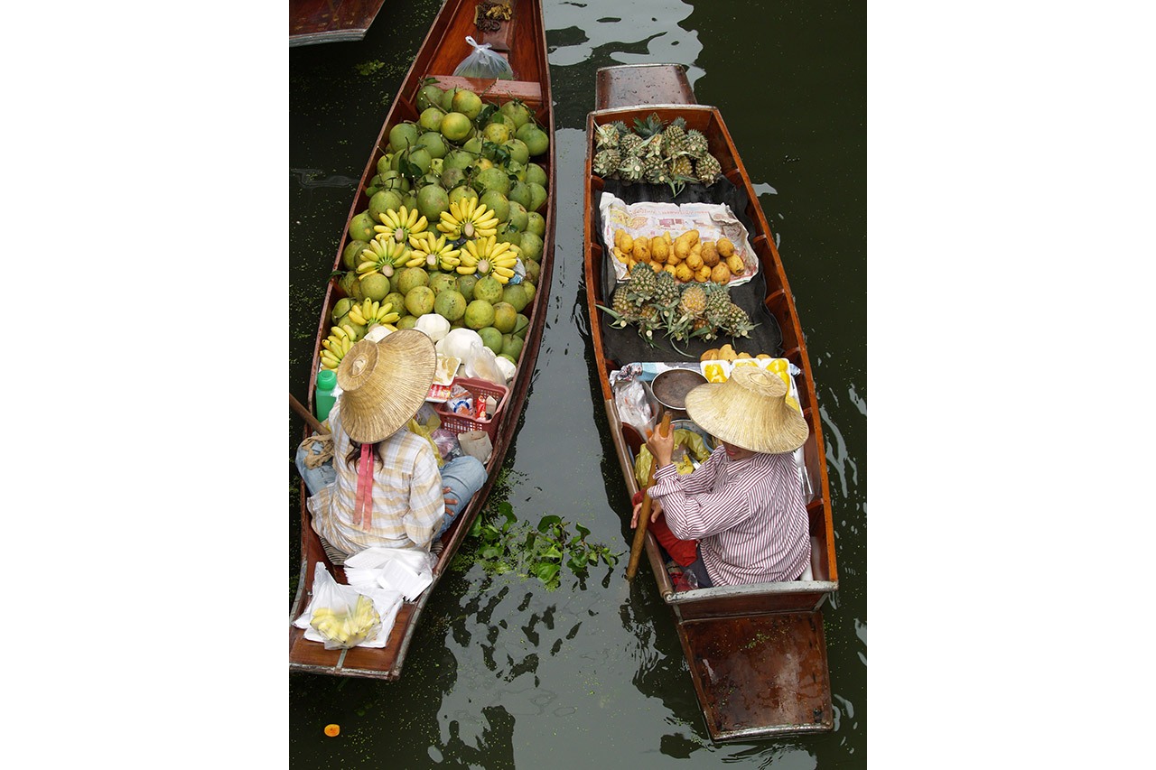 Overhead view of two boats loaded with fruit at a floating market, Thailand
