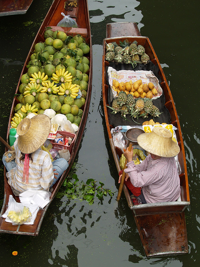 Overhead view of two boats loaded with fruit at a floating market, Thailand