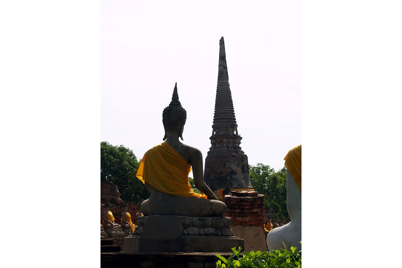 Buddha statue draped in saffron robe facing a chedi, Ayutthaya