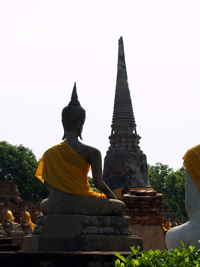 Buddha statue draped in saffron robe facing a chedi, Ayutthaya