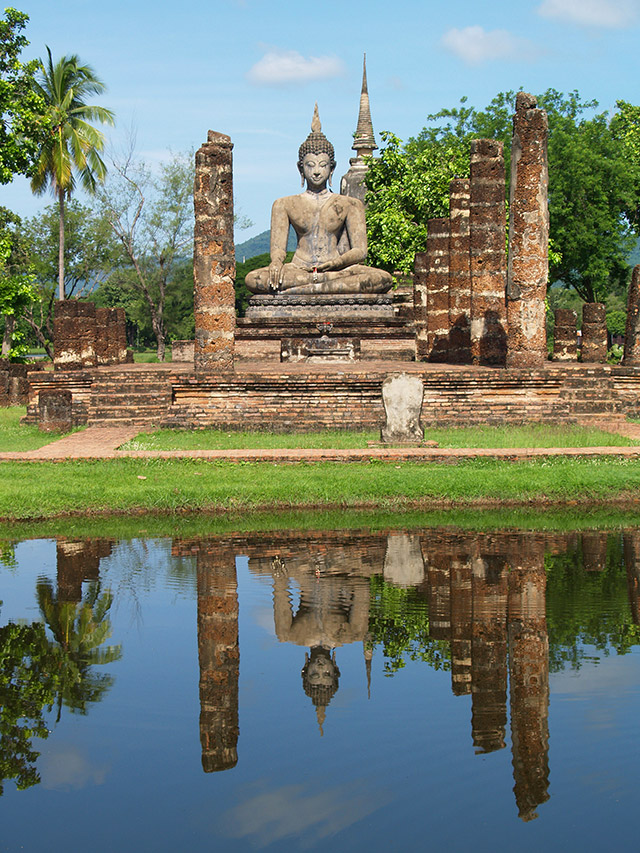 Seated Buddha reflected in a pond at Sukhothai historical park