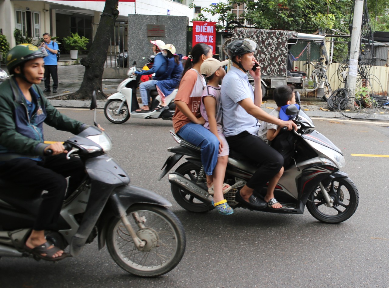 Families riding motorbikes through a Hanoi street